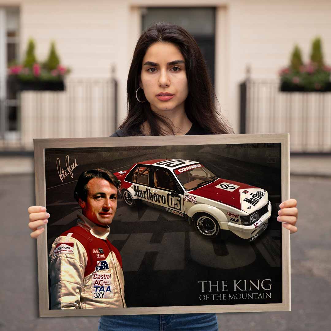 Women holding framed Peter Brock Signed Art.