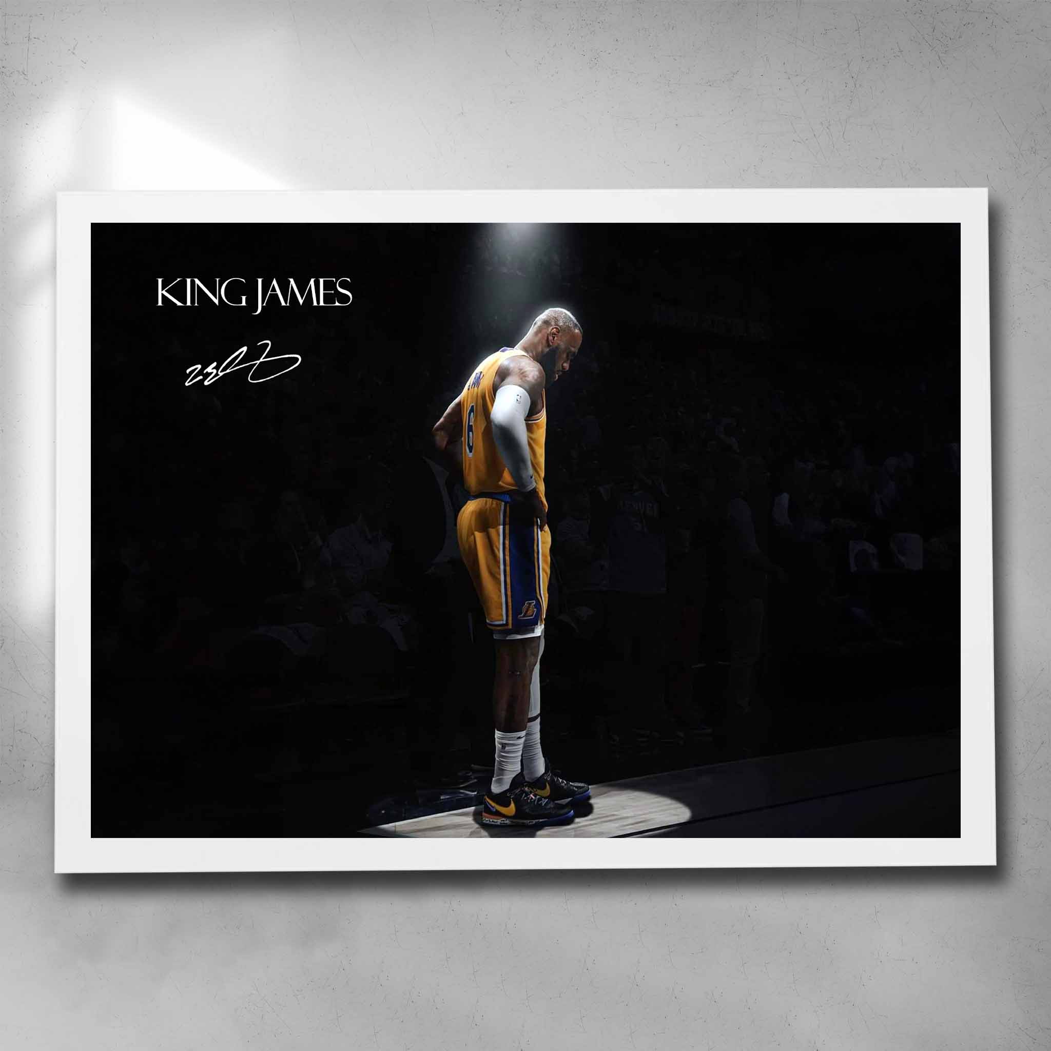 White framed King James art by Sports Cave, showcasing the legendary basketball icon spotlighted against a blurred audience background.